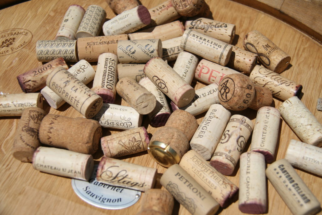 Photo of various used wine corks on wine barrel top by Phil Bourke